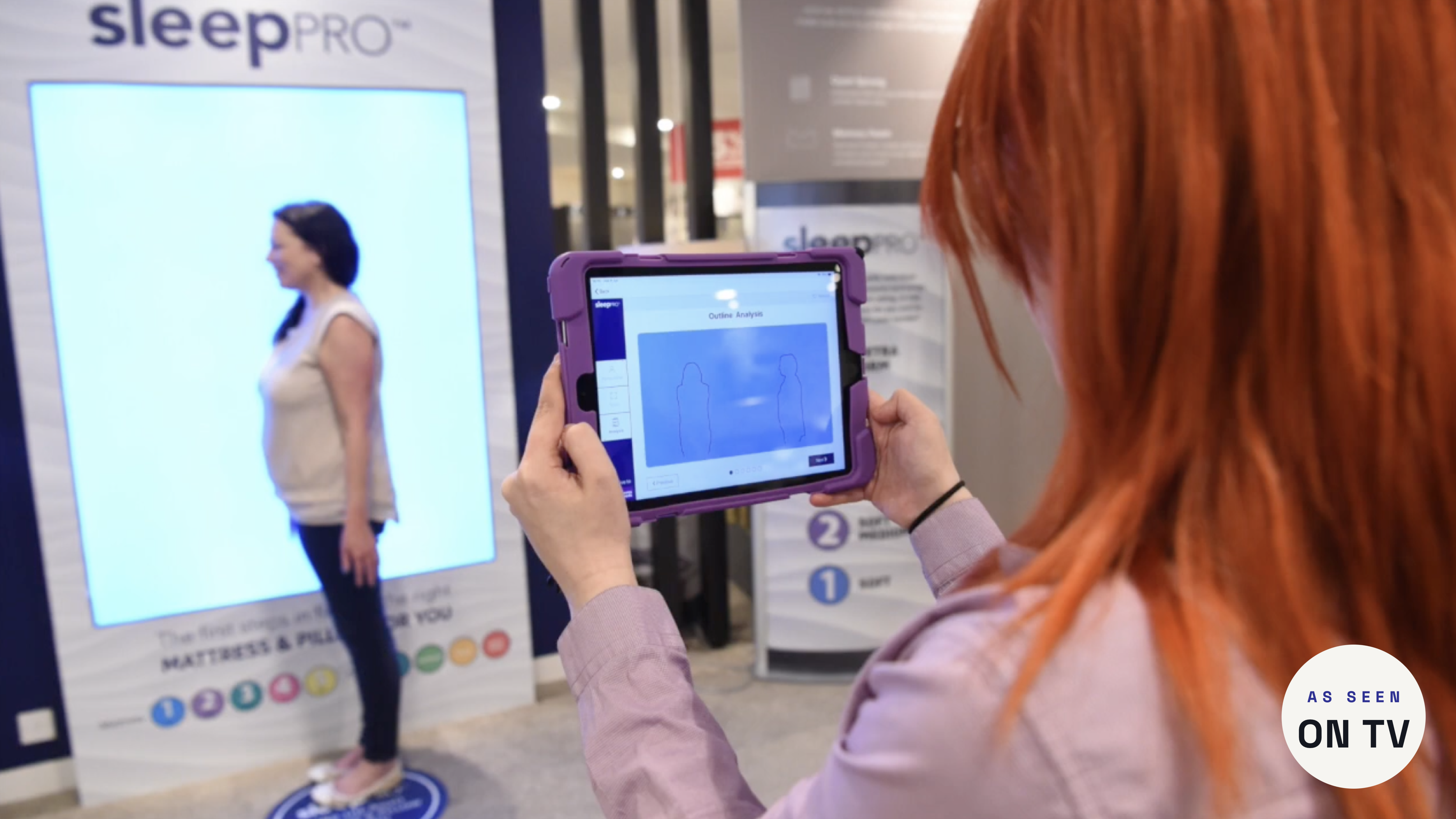 A colleague using the Sleep Pro iPad to capture a customer's body-shape scan in store